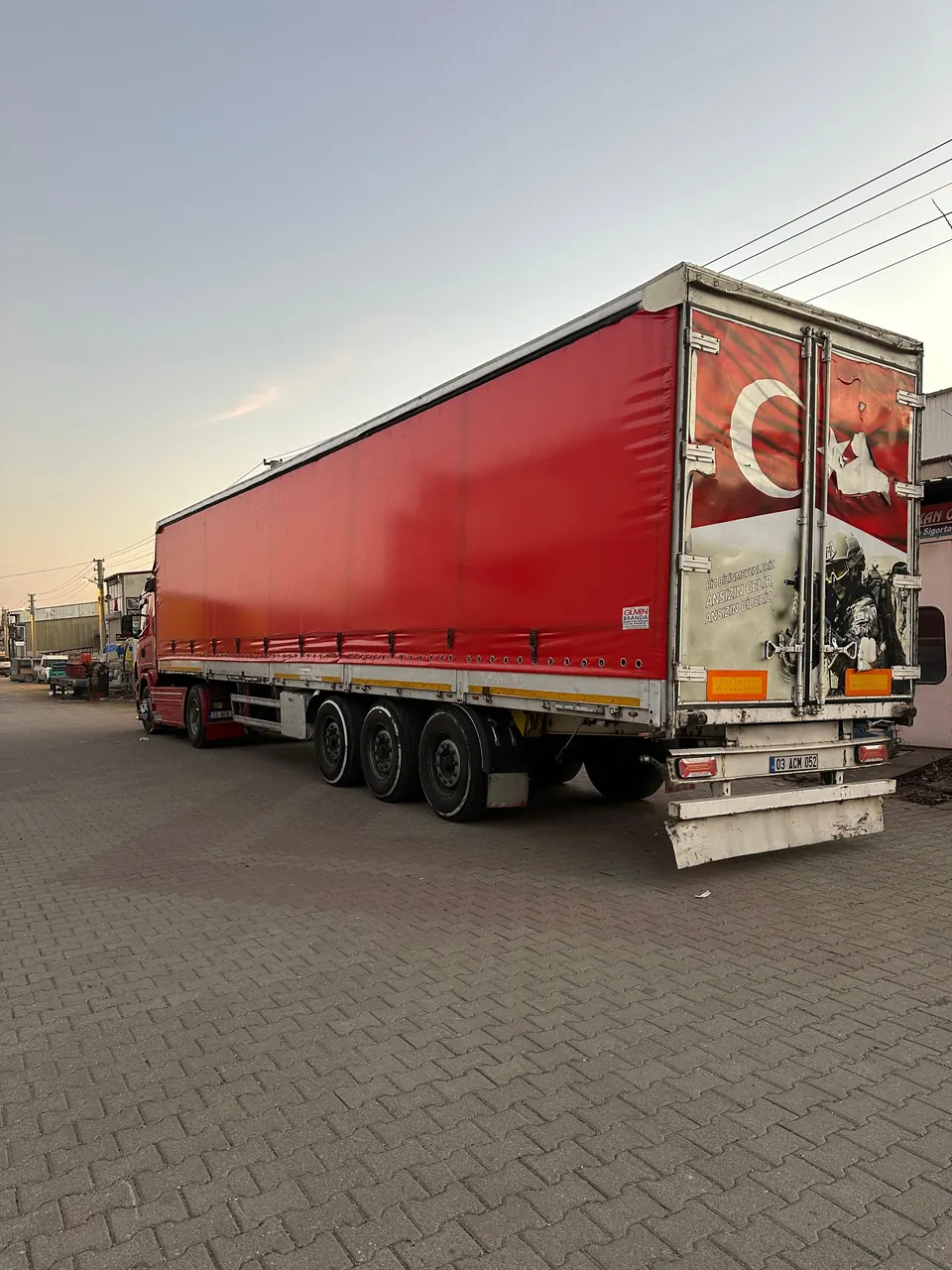 Tır dorsesine dikilen kırmızı yan perde (tenteli dorse brandası)